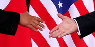 Zwei Hände vor dem Händeschütteln. Es sind die Hände Kim Jong Uns und Donald Trumps