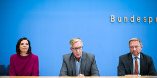 Katrin Göring-Eckardt, Dietmar Bartsch und Christian Lindner sitzen in einer Reihe vor einer blauen Wand im Saal der Bundespressekonferenz