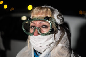 Eine Frau hat eine Schutzbrille auf und ist vermummt Eine Frau hat eine Schutzbrille auf und ist vermummt