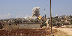 Luftangriff bei Idlib, rauch steigt aus einem Gebäude aus