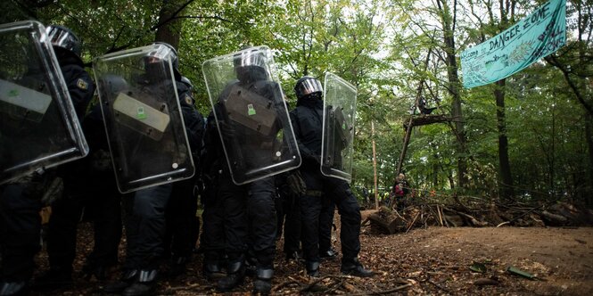 Schwer vermummte Polizisten im Wald