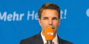 Jörg Nigge spricht in ein Mikrophon.