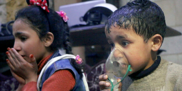 Syrische Kinder, eins mit Hand vorm Mund, ein anderes mit Atemschutzmaske