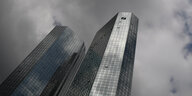 dunkle Wolken hängen über zwei Türmen mit dem Logo der Deutschen Bank _ Finanzkrise