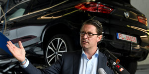 Bundesverkehrsminister Andreas Scheuer (CSU) vor einem Testfahrzeug im Hauptabgaslabor des Kraftfahrt-Bundesamtes.