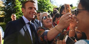 Emmanuel Macron (l), Präsident von Frankreich, lässt sich während des Tags der Offenen Tür im Elyseepalast mit einer Frau fotografieren.
