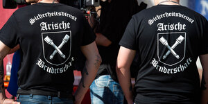 Zwei Besucher des "Schild und Schwert"-Festivals mit T-Shirts mit der Aufschrift "Arische Bruderschaft".