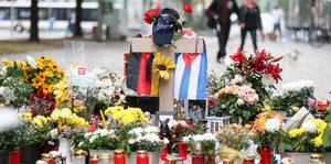 Die deutsche und die kubanische Flagge, zahlreiche Blumen und Kerzen wurden an der Stelle niedergelegt an der ein junger Mann erstochen wurde