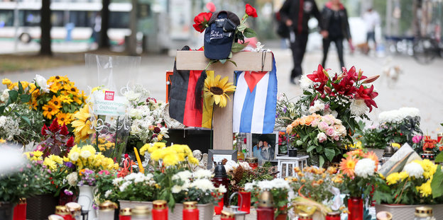 Die deutsche und die kubanische Flagge, zahlreiche Blumen und Kerzen wurden an der Stelle niedergelegt an der ein junger Mann erstochen wurde