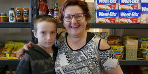 Frau und Junge stehen vor Supermarktregalen