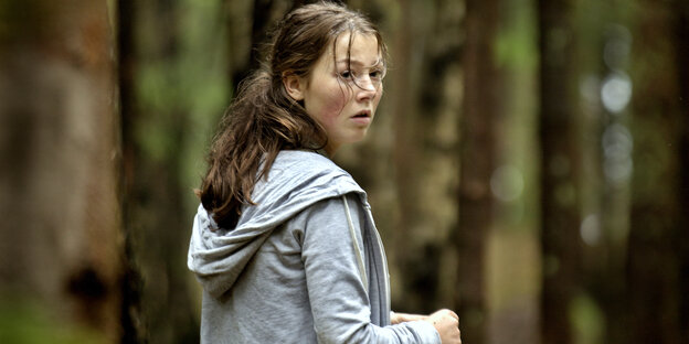 Szene aus dem Film „Utoya 22. Juli“: Eine Frau in einem Wald dreht sich um