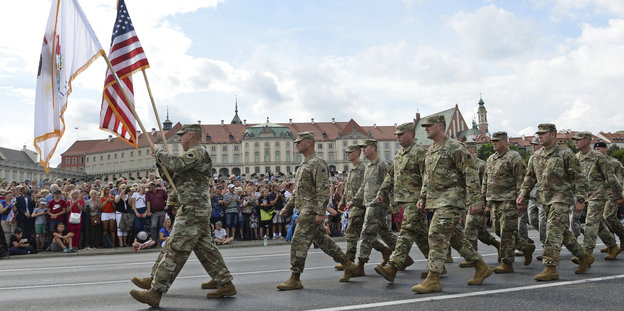 Eine Militärparade zieht durch eine Straße
