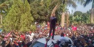 Bobi Wine auf einem Autodach vor vielen Leuten