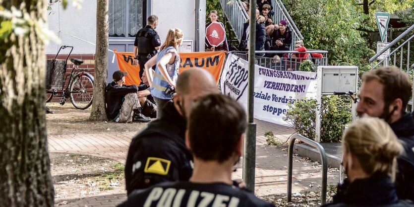 Demonstranten sitzen auf den Treppen eines Hauseingangs.