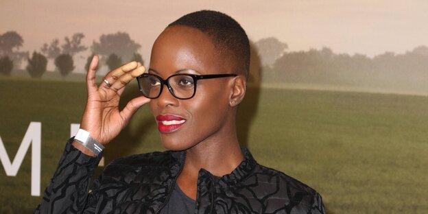 Florence Kasumba rückt ihre Brille zurecht