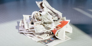 Eine zerknüllte Zeitung liegt auf dem Boden