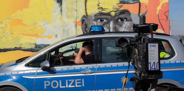 Polizeiauto vor einem Wandbild