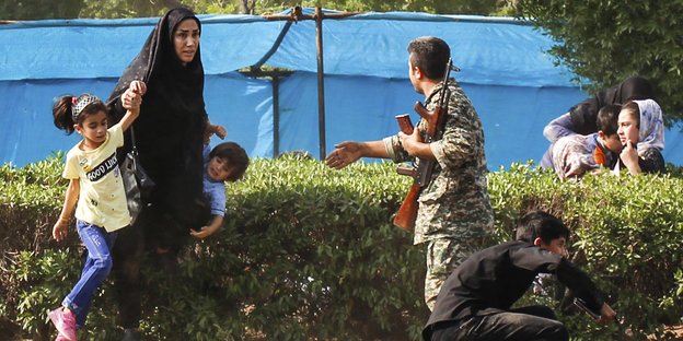 Iranischer Soldat hilft einer Schutz suchenden Frau