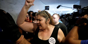 Eine Frau demonstriert gegen Kavanaugh, sie trägt einen Button auf dem steht "I Believe Dr. Christine Blaisey Ford"