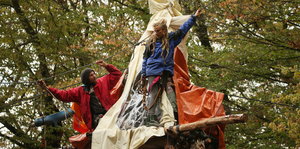 Im Hambacher Forst stehen Demonstranten angeseilt auf einem Tripod.