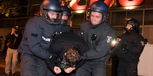 Polizisten überwältigen Demonstranten