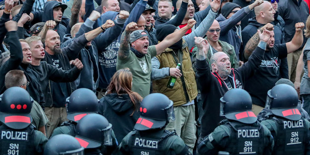 Polizisten halten rechte Demonstranten zurück
