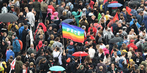 Viele Menschen demonstrieren auf der Straße in Chemnitz gegen Rassismus, in der Mitte ist eine große Regenbogenflagge, auf der Pace steht