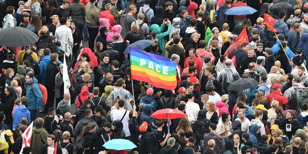 Viele Menschen demonstrieren auf der Straße in Chemnitz gegen Rassismus, in der Mitte ist eine große Regenbogenflagge, auf der Pace steht