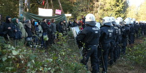 PolizistInnen stehen AktivistInnen im Hambacher Forst gegenüber