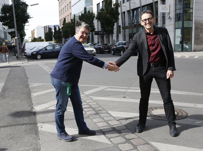 Die beiden Bezirksbürgermeister geben sich die Hand an der Bezirksgrenze