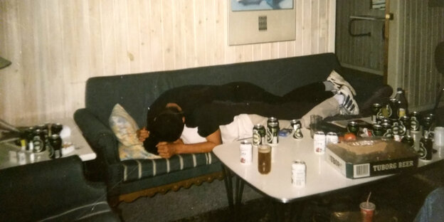 Zwei Männer auf einer Couch, davor Bierdosen Zwei Männer auf einer Couch, davor Bierdosen