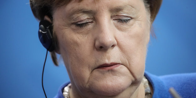 Angela Merkel hat die Augen zu, als würde sie schlafen