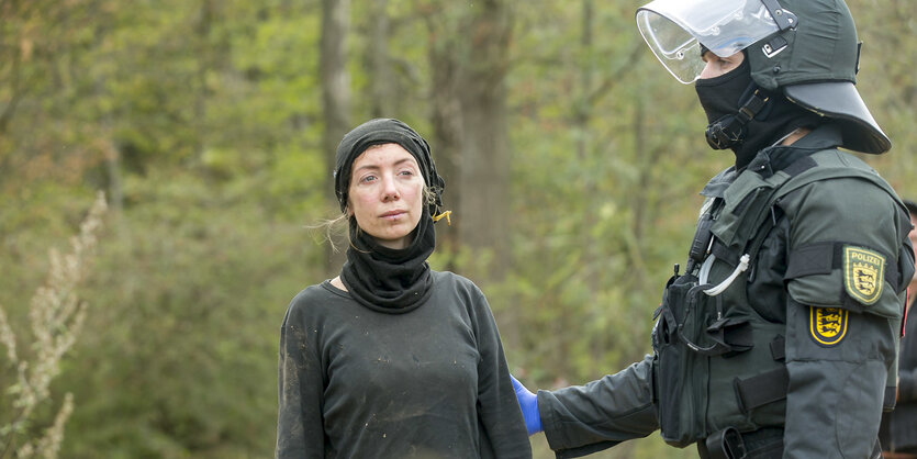 Die Aktivistin im Hambacher Forst wird von einem Polizisten festgenommen