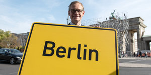Michael MÜller trägt ein Berliner Ortsschild