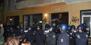 Polizisten stehen vor eniem haus