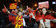 Einige Menschen protestieren mit Flaggen und Schildern nach dem Referendum in Mazedonien auf der Straße