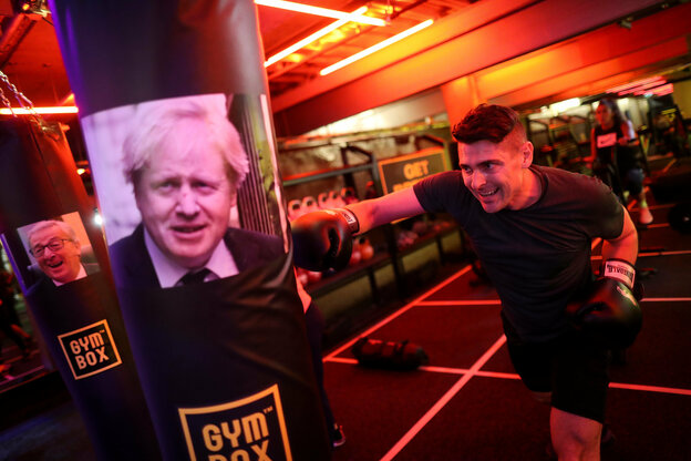 Ein Mann boxt in einem Fitnesstudio auf ein Bild des Politikers Boris Johnson von der Conservative Party.