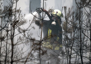 Ein Feuerwehrmann löscht einen Brand im Wald