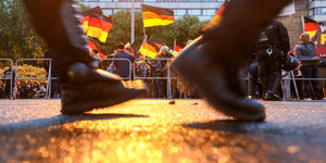 Stiefel marschieren, im Hintergrund Deutschlandflaggen