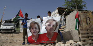 Palästinensische Kinder halten Poster mit einem Porträt der deutschen Bundeskanzlerin Angela Merkel