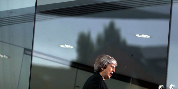 Theresa May vor spiegelnden Fenstern