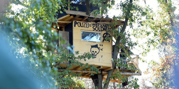 Ein Baumhaus, auf dem steht: Polizei gleich Wirtschaftssolidarität