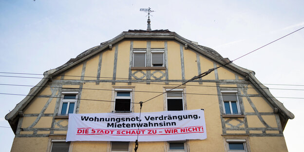 Haus mit Transparent, auf dem steht: Wohnungsnot, Verdränung, Mietenwahnsinn, die Stadt schaut zu, wir nicht