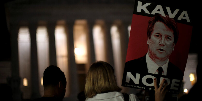 Vor dem Obersten Gericht in Washington hält eine Frau ein Plakat mit dem Gesicht von Brett Kavanaugh und der Aufschrift "Kava Nope"