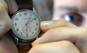 Eine Person untersucht eine Armbanduhr