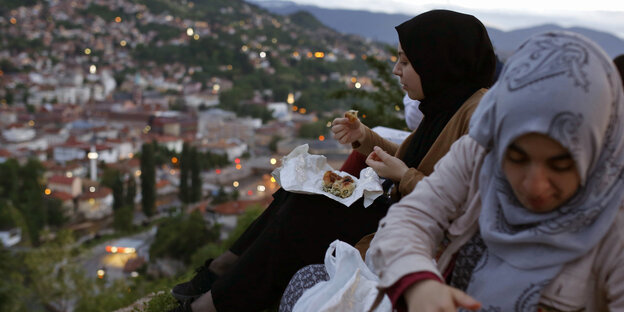 Zwei Frauen essen auf einem Hügel in der Nähe einer alten Festung