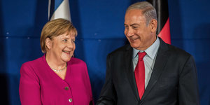 Bundeskanzlerin Angela Merkel und der israelische Premierminister Benjamin Netanhaju stehen lächelnd nebeneinander