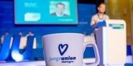 Eine Tasse mit Werbemotiv steht beim Landestag der CDU-Nachwuchsorganisation Junge Union Thüringen auf einem Tisch