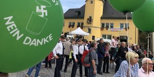 Menschen stehen auf einem Marktplatz in Apolda und demonstrieren gegen ein Rechtsrock-Konzert. Sie haben grüne Ballons mit der Aufschrift „Nazis? Nein, danke“ dabei