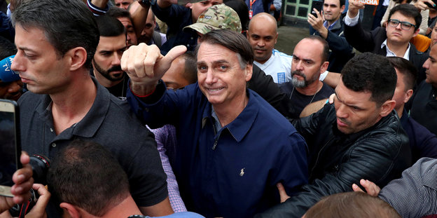 Jair Bolsonaro in einer Menschenmenge, er zeigt den Daumen nach oben
